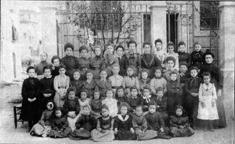 Nenes i la mestra a la porta de l'escola (1910 aprox.)